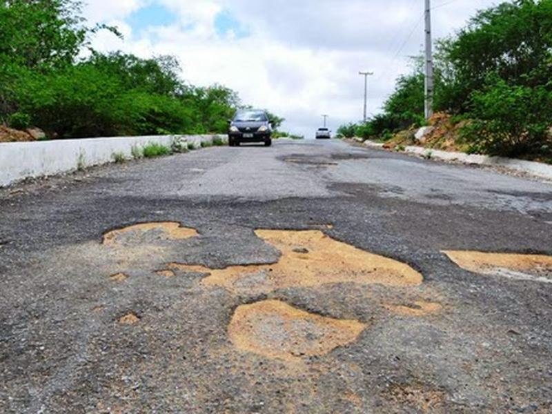 A paved street covered in potholes