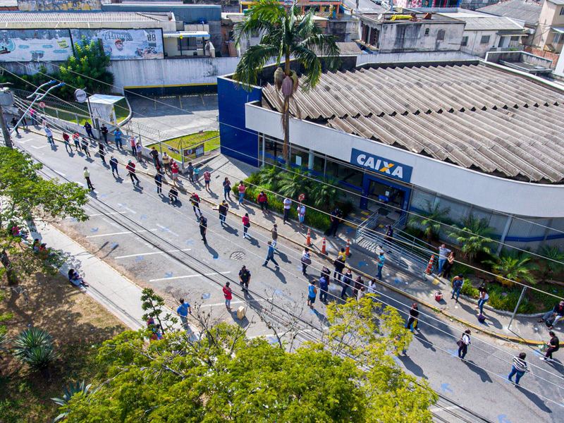 Aerial view of a queue of hundreds of people on the pavement outside a bank branch